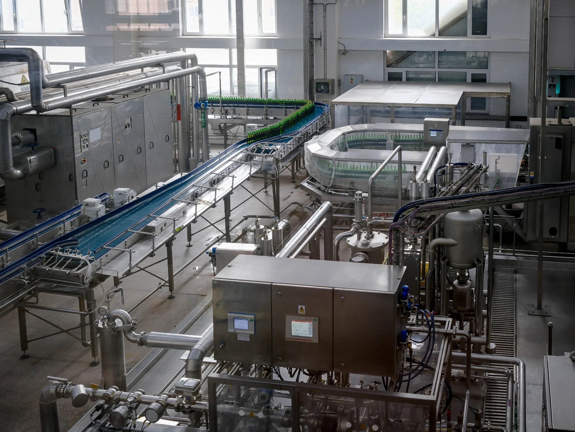 Bottling line with bottles, conveyors and stainless steel machinery